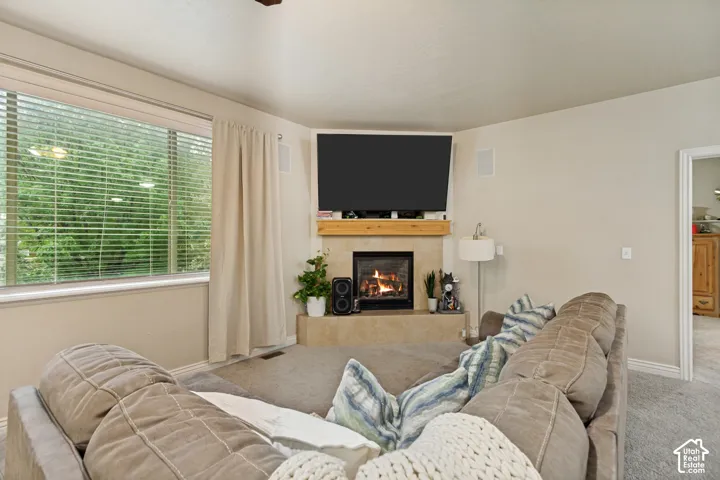 Corner fireplace featuring a tile surround, natural wood mantel, and built-in wall speakers