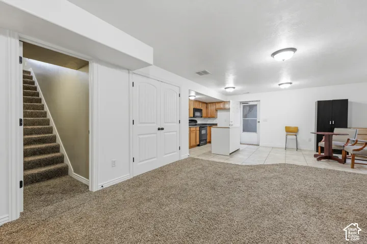 Open floor plan featuring carpeting, tile flooring, built-in double closet doors, and recessed ceiling lighting