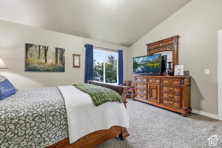 Vaulted ceilings, neutral wall tones, and large dual-pane sliding window