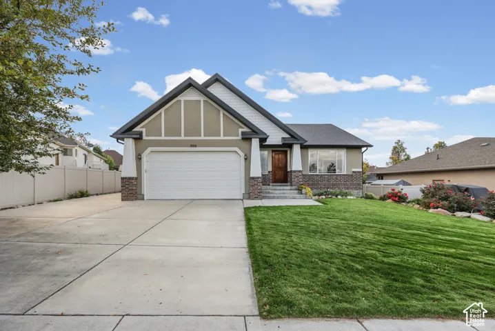 Craftsman-inspired exterior featuring stone veneer accents, multi-gabled roofline, decorative timber framing, concrete driveway, and manicured lawn