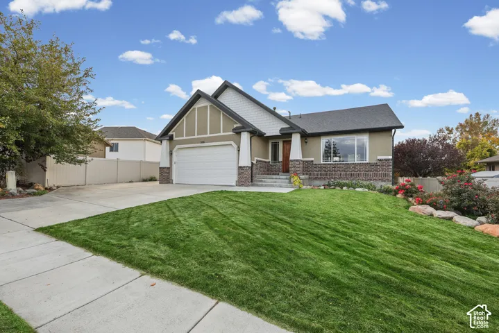 Welcoming front elevation featuring a pitched gable roof with decorative timber accents, white two-car garage, and brick detailing