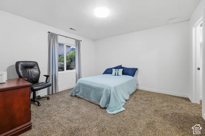 Neutral-toned interior space featuring carpeting, white wall finishes, and a single-pane window