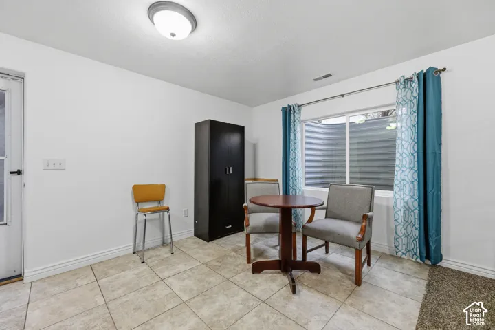 Ceramic tile flooring, white walls, and a recessed window well with a sliding window