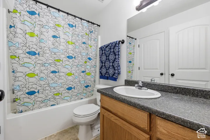 Bathroom featuring a wood-finish vanity with a stone-composite countertop, an integrated oval basin, a full-width vanity mirror, and a tub-shower combination with a surround