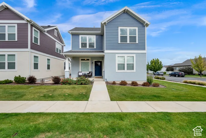 Two-story residence featuring horizontal lap siding, stucco exterior, covered front porch, and a concrete walkway