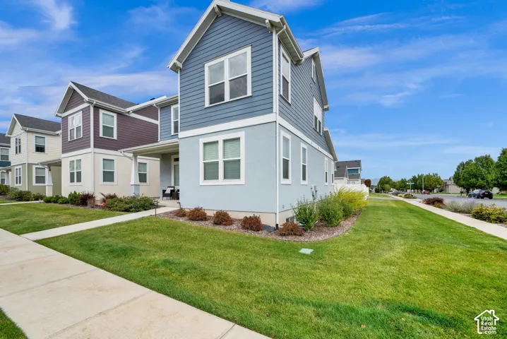 Two-story exterior featuring blue horizontal lap siding, light-toned stucco lower facade, gabled roofline, and an integrated front porch