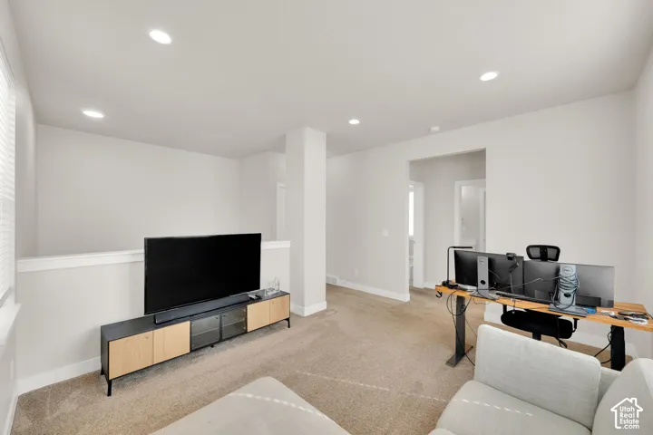 Open-concept interior space featuring neutral wall paint, recessed lighting, wall-to-wall carpeting, and a knee wall partition