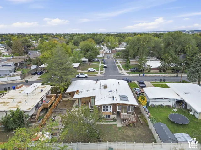 Aerial perspective featuring a shingled exterior, metal roofing, multiple skylights, and a wood-deck staircase