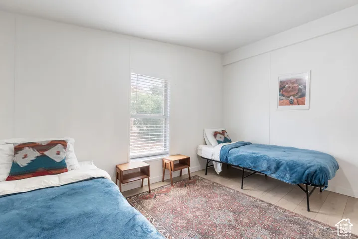 Neutral wall finish, light-toned wood-finish flooring, and a single-pane window