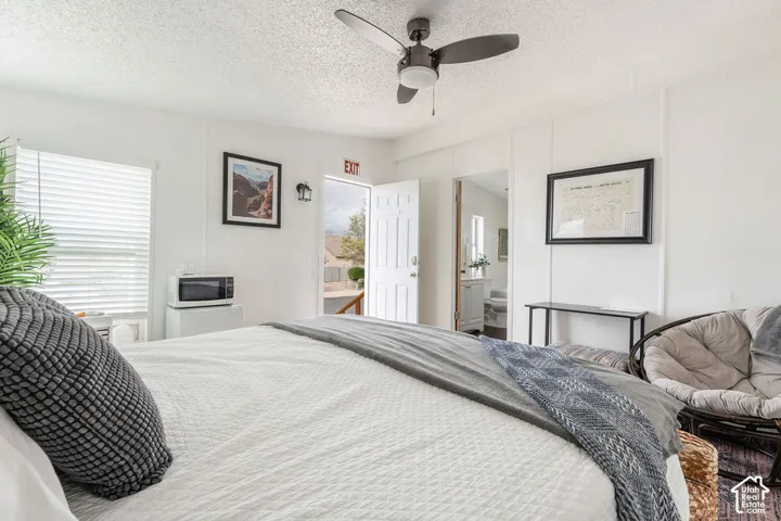 Neutral wall paneling, ceiling fan with integrated lighting, and horizontal window blinds