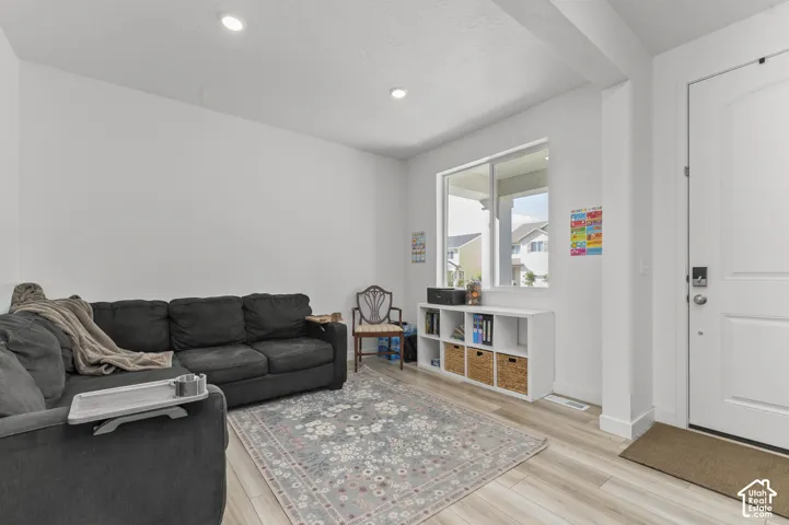 Neutral interior space featuring wood-finish flooring, recessed lighting, and a single-hung window