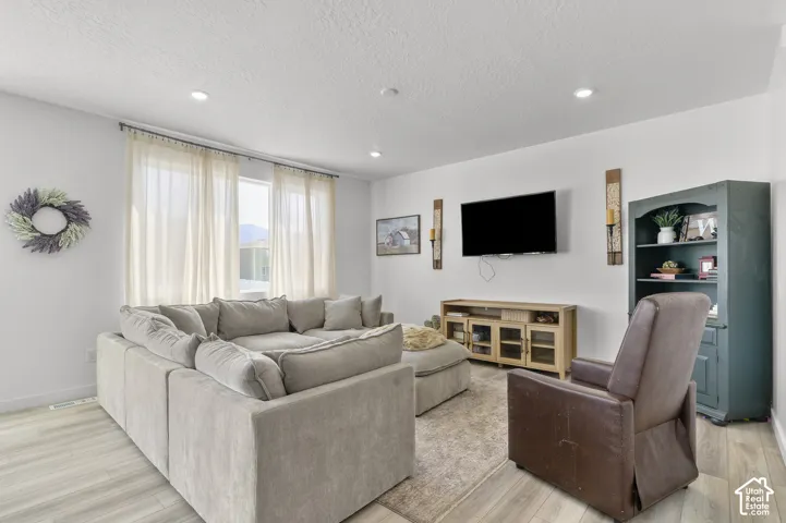 Living area featuring wood-finish flooring, neutral walls, and recessed lighting