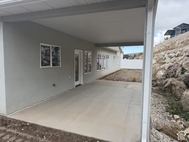 Covered concrete patio featuring recessed lighting, smooth stucco exterior finish, and multiple glass-paned windows