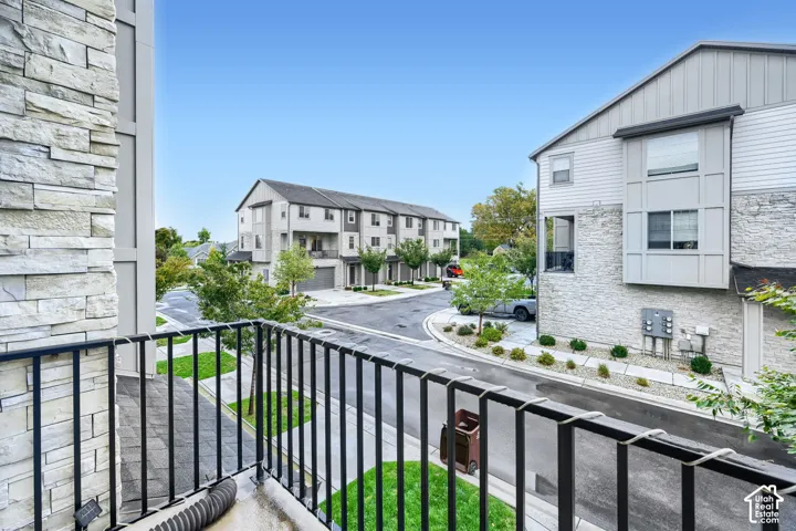 Private balcony featuring black metal railings, stone veneer siding, and horizontal siding accents