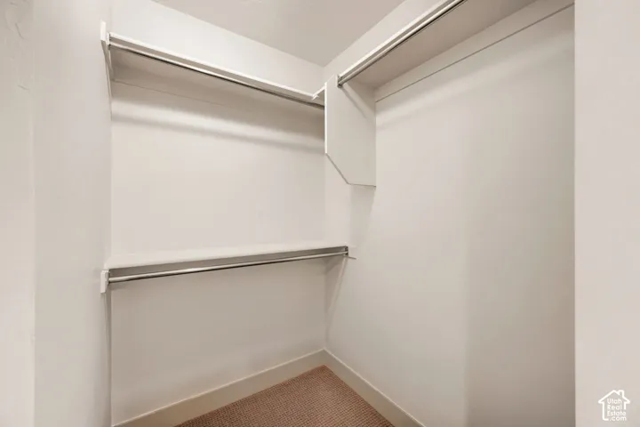 Closet featuring tiered shelving and integrated metal garment rods