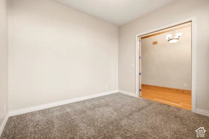 Neutral-toned wall paint, wall-to-wall carpeting, wood-finish flooring, and double-door entry