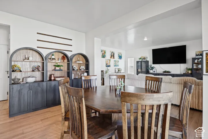 Custom built-in arched cabinetry with wood-tone shelving, dark-finish lower cabinets, and wood-finish flooring