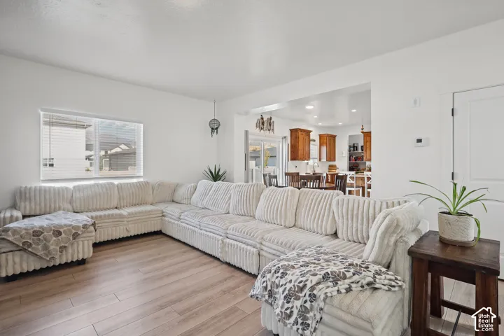 Living area featuring wood-finish flooring, a neutral color palette, and a large window