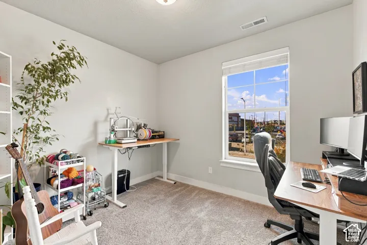 Carpeted room with a large window, light gray wall paint, and a built-in shelf