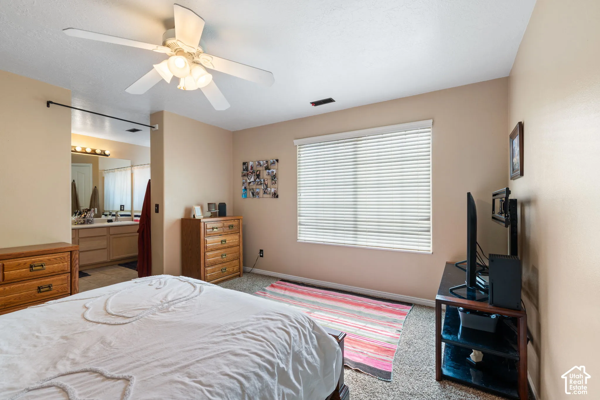 Room featuring a ceiling fan with integrated lighting, wall-to-wall carpeting, and a window with horizontal blinds