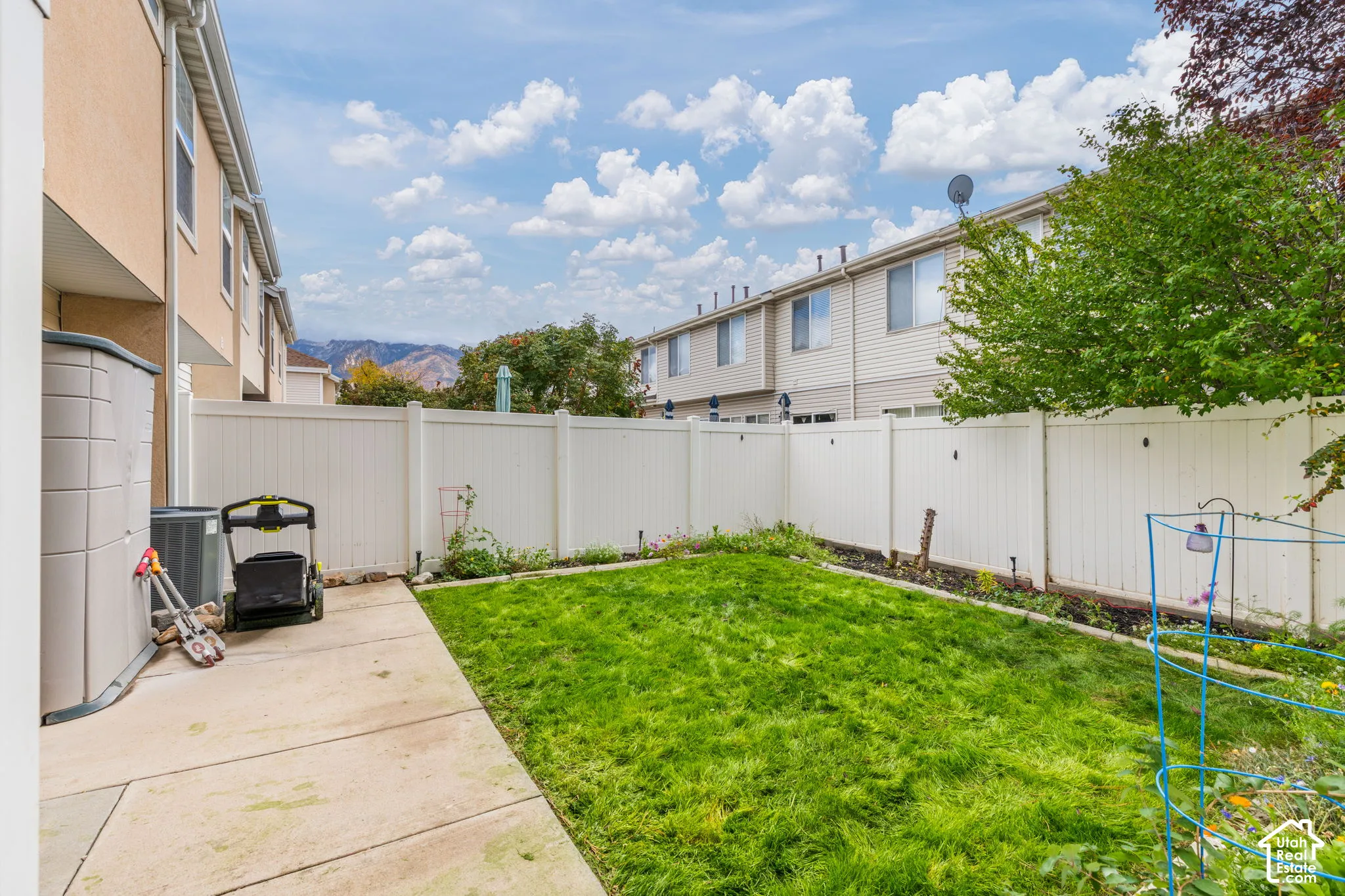 Fenced rear yard featuring a concrete patio and lawn area