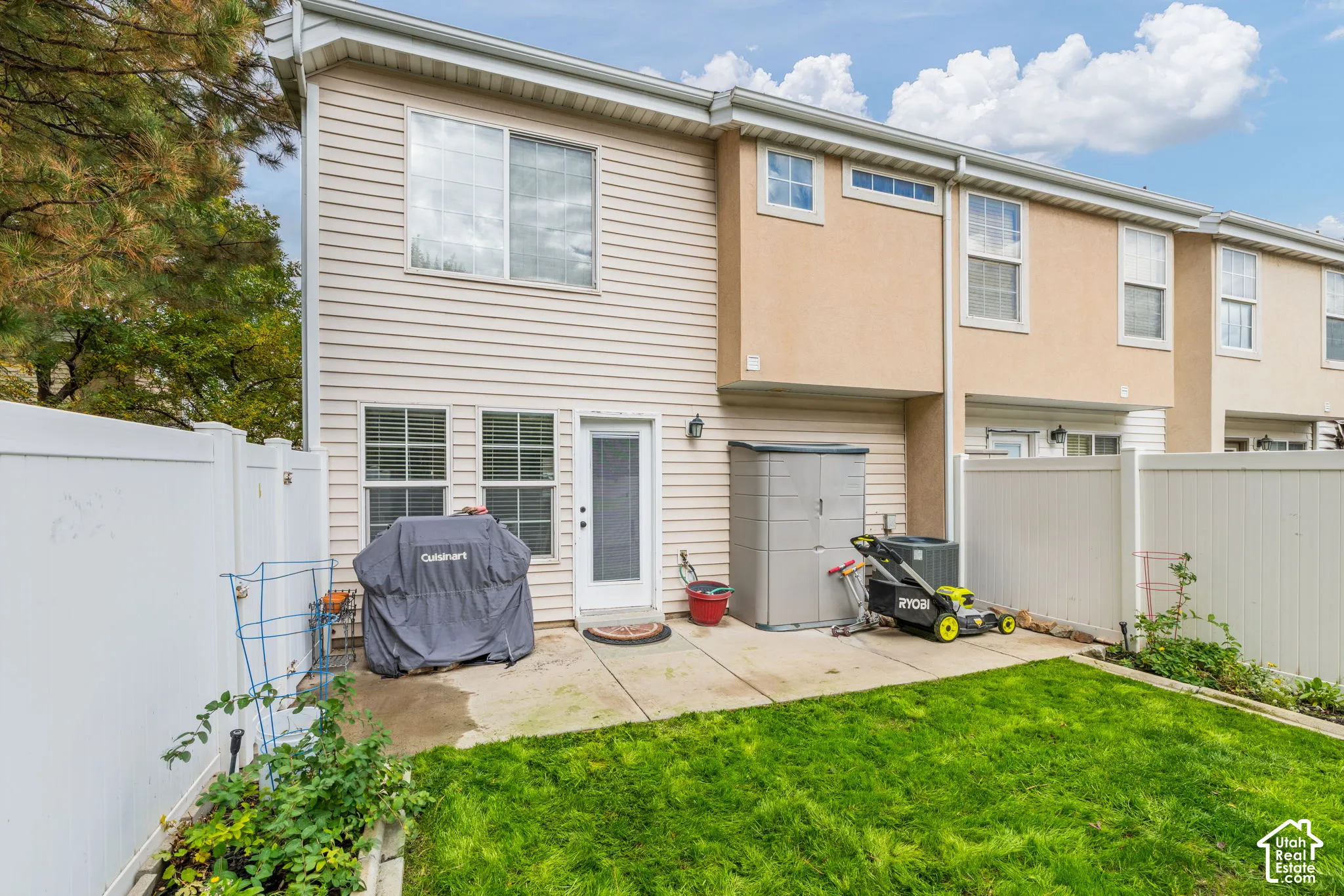Exterior features include a two-story siding and stucco facade, a concrete patio, and a private fenced yard