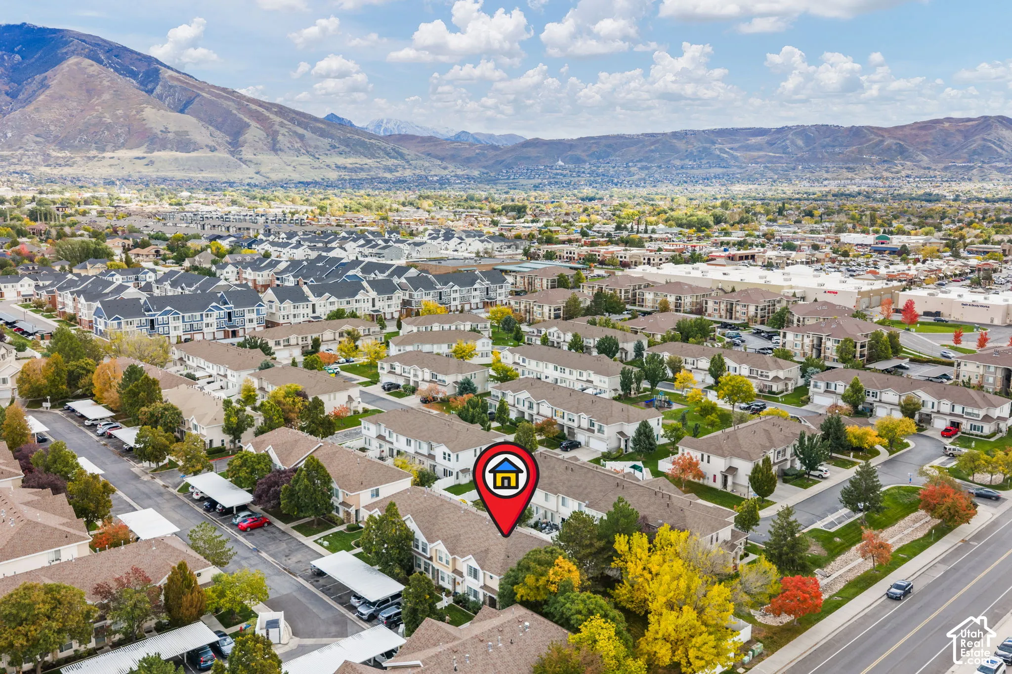 Aerial perspective featuring mountain scenery, multi-level residential architecture, and mature trees