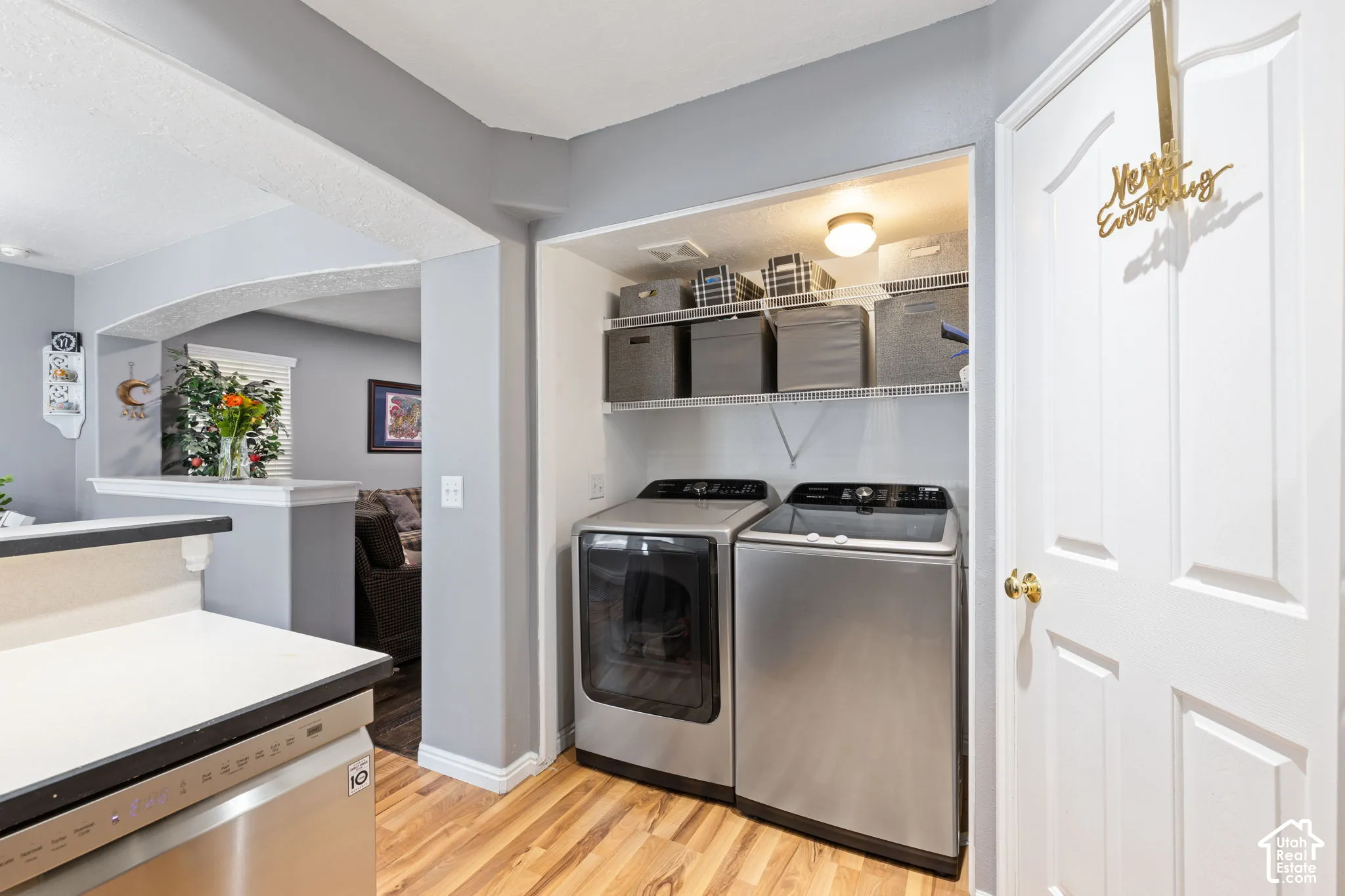 Laundry area featuring wire shelving, wood-finish flooring, and a six-panel door