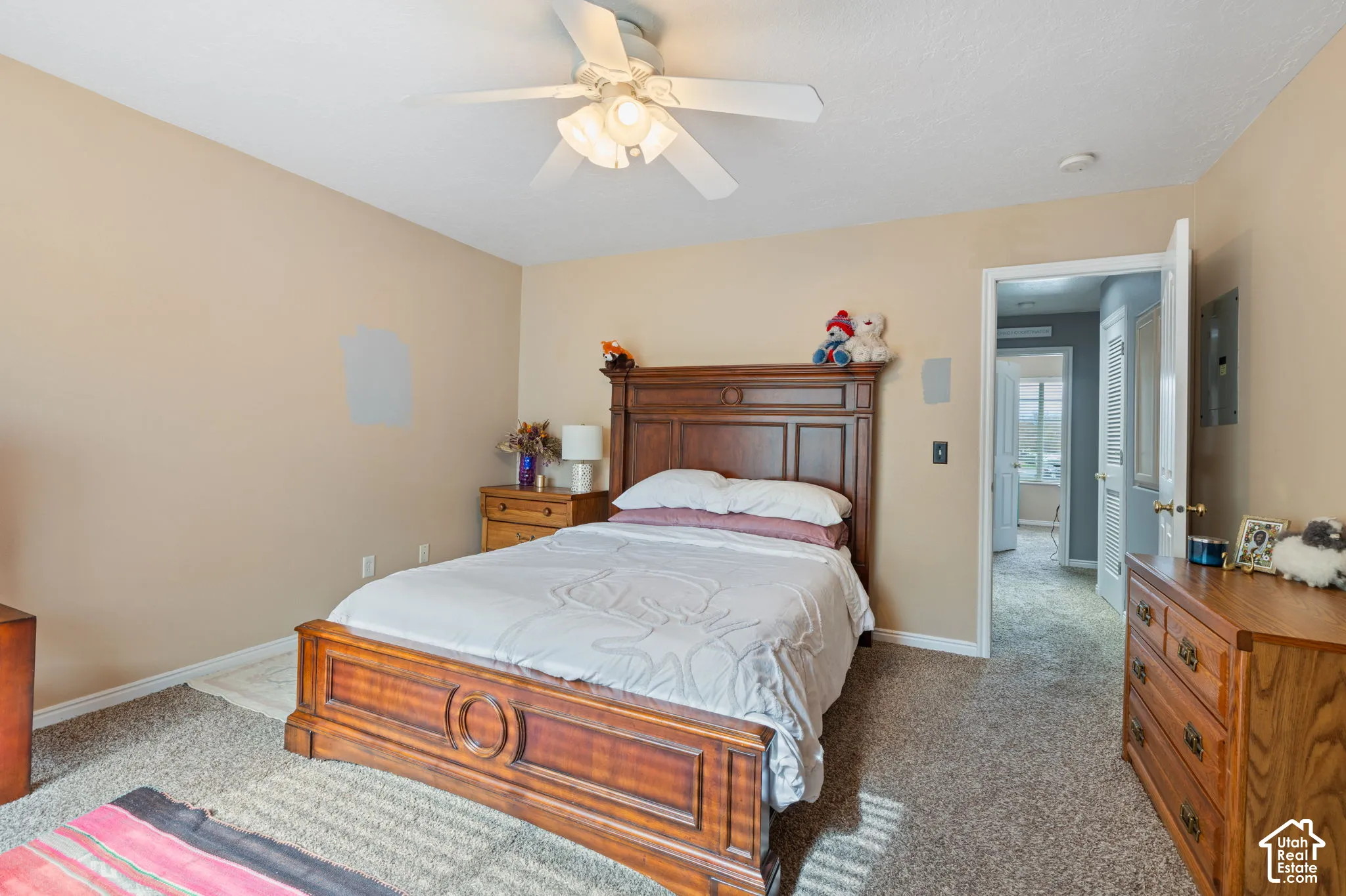 Neutral-toned room featuring wall-to-wall carpeting and a ceiling-mounted light fixture with a fan