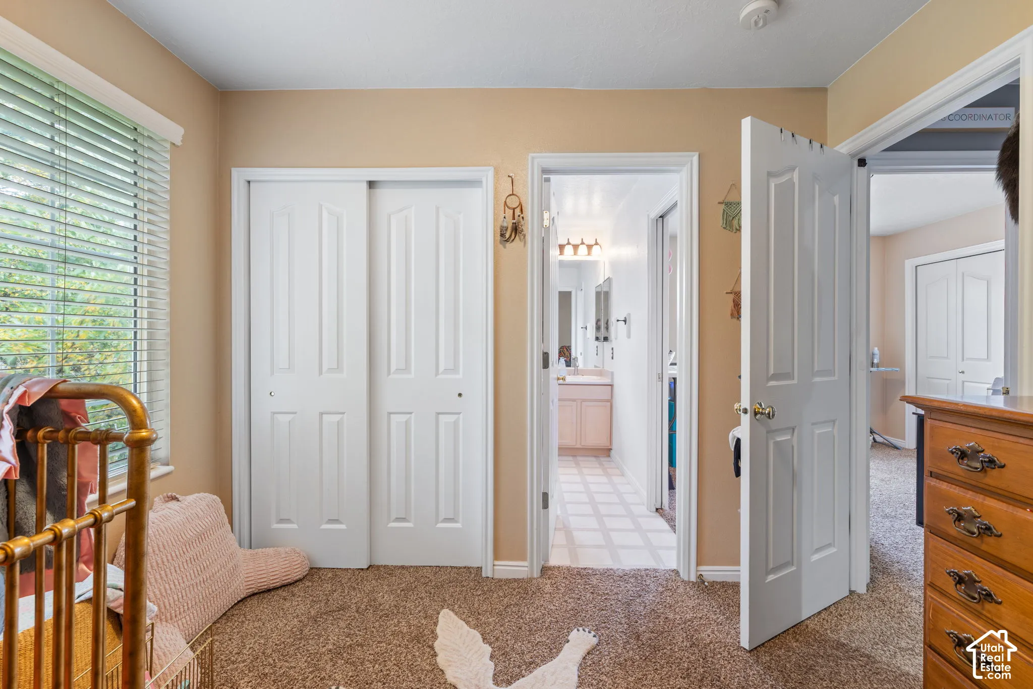 Room featuring wall-to-wall carpeting, white-paneled closet doors, and multi-pane horizontal blinds