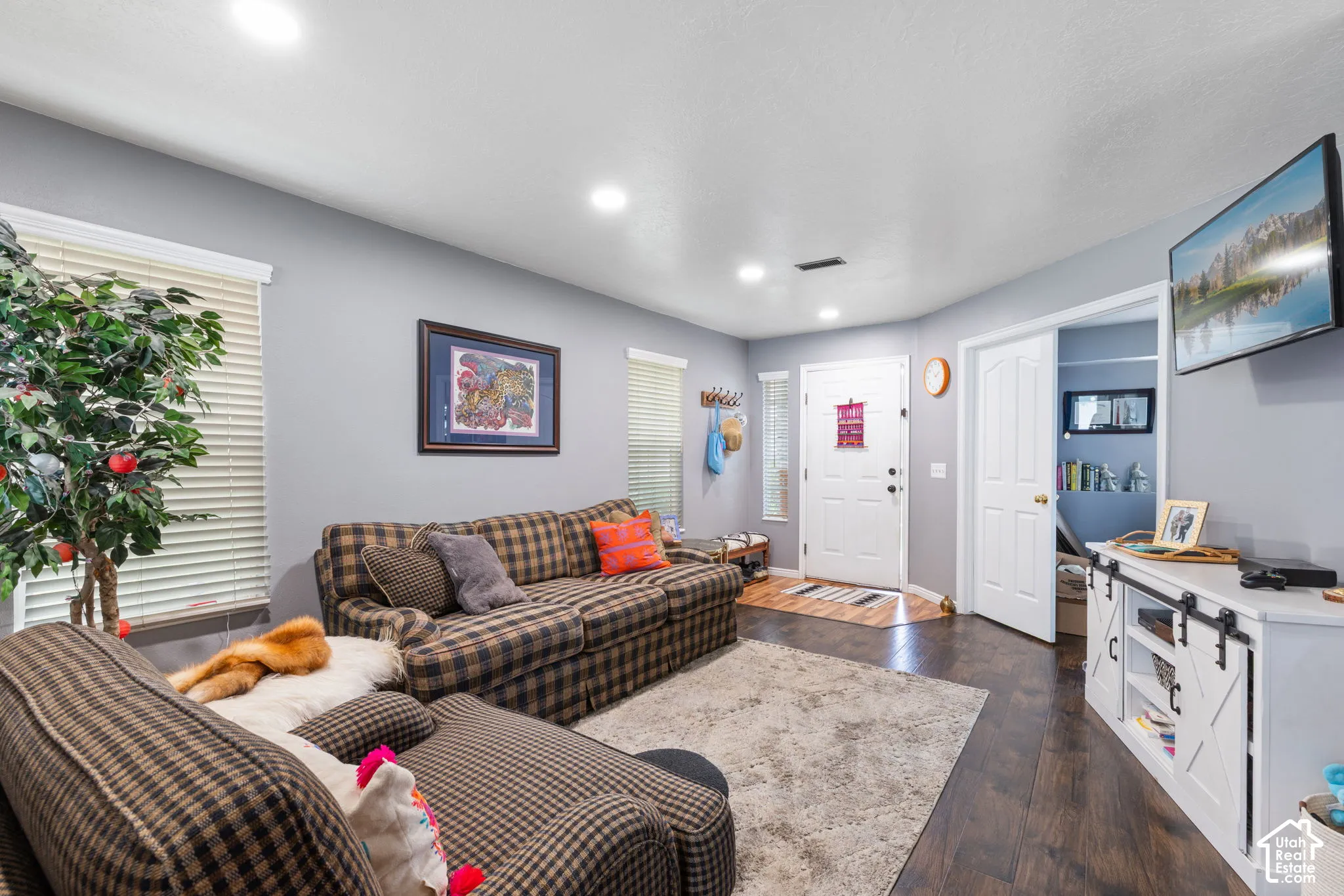 Wood-finish flooring, recessed lighting, multi-pane window blinds, solid-core interior doors, and a paneled entry door