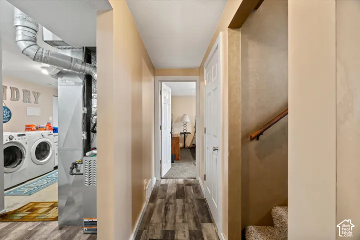 Hallway featuring wood-finish flooring, white paneled doors, and an exposed metal furnace unit