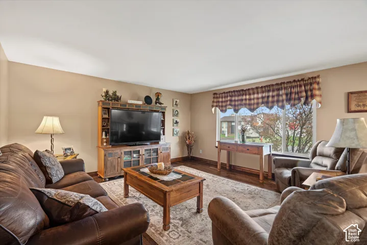 Living area featuring wood-finish flooring, neutral wall paint, and a large multi-pane window
