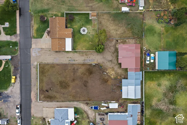 Aerial view featuring a spacious lot with fenced perimeter and a detached outbuilding