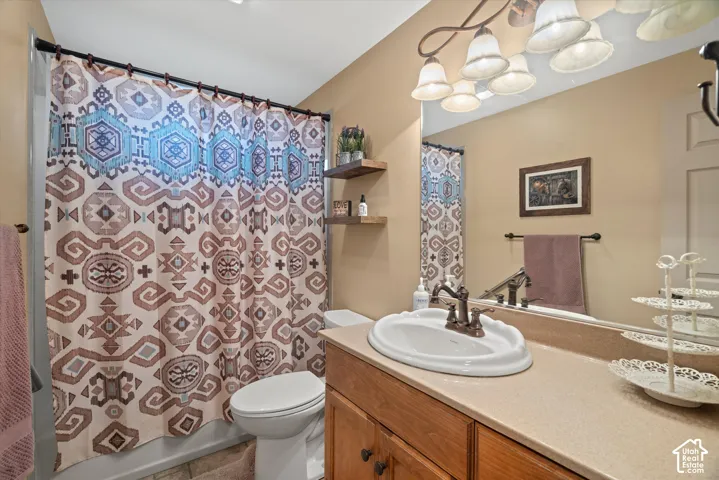 Bathroom vanity featuring a solid surface countertop, an integrated oval basin, bronze-tone hardware, wood-finish cabinetry, and two wall-mounted floating wood shelves