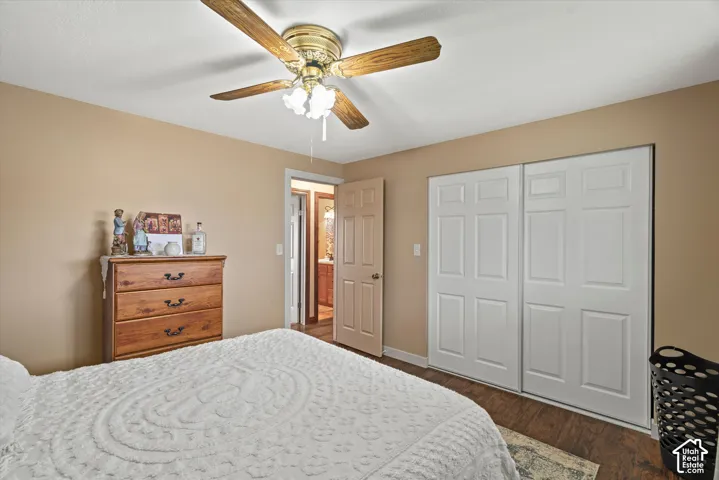 Bedroom featuring wood-finish flooring, a ceiling fan with integrated lighting, and a dual-panel closet with sliding doors