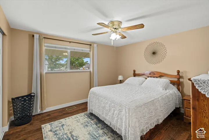 Wood-finish flooring, metal-frame window, and multi-blade ceiling fan with integrated lighting