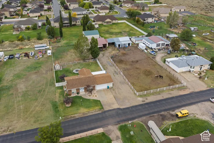 Residential property featuring a sprawling lot, fenced-in pasture area, multi-bay detached outbuilding, and an attached garage