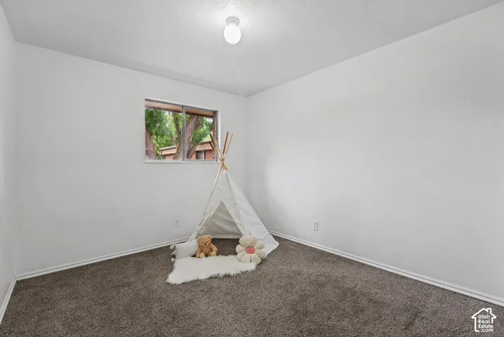 Interior room featuring neutral wall paint, wall-to-wall carpeting, and a single-pane sliding window