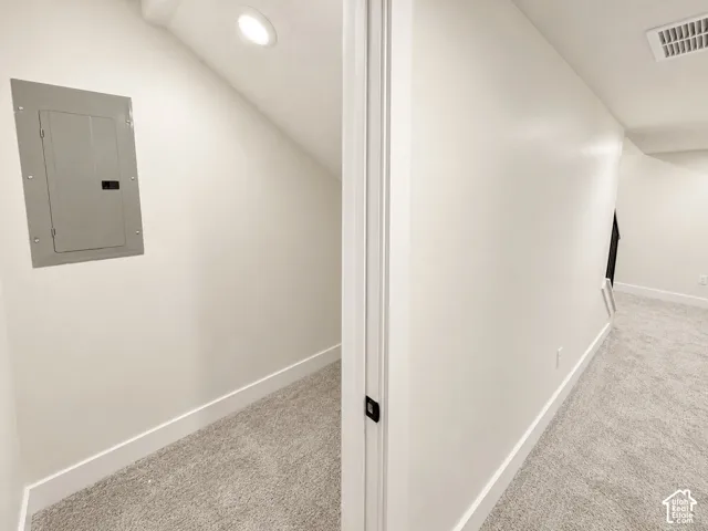 Storage area with carpeted flooring, recessed lighting, and the electrical panel