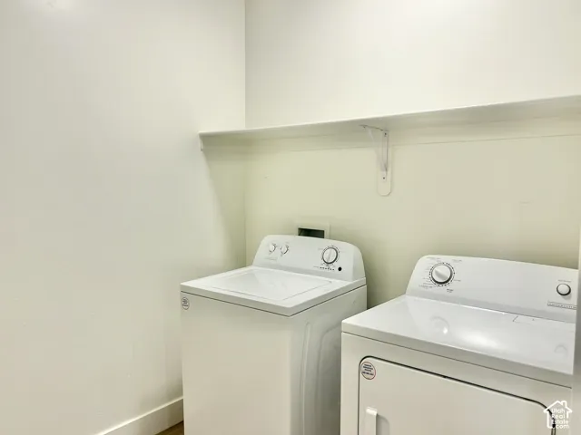 Dedicated laundry area featuring a wall-mounted shelving unit and hookups for a washer and dryer