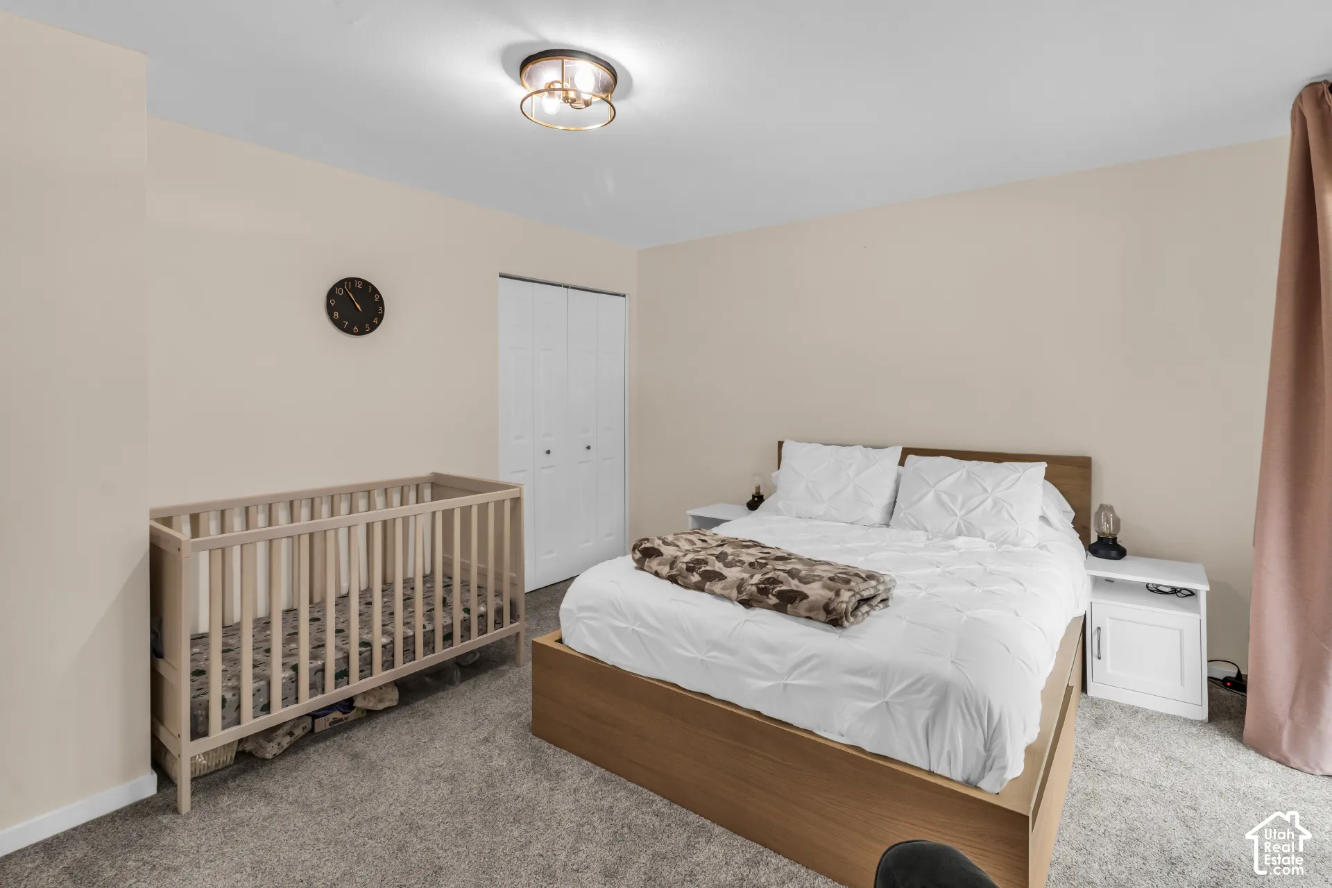 Room featuring neutral-toned walls, carpeting, a dual-door closet, and a flush-mount circular ceiling light fixture