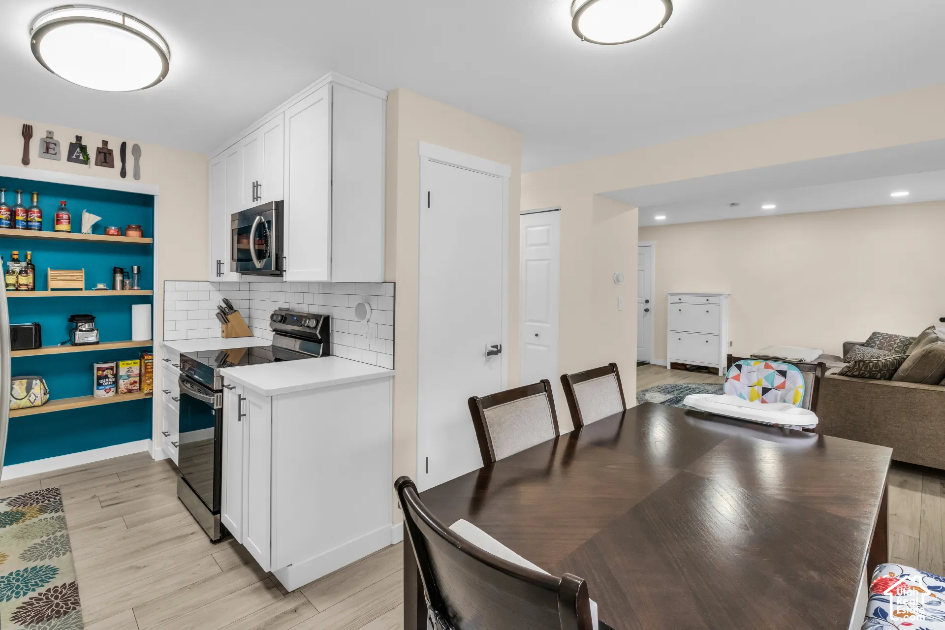 Kitchen featuring white shaker-style cabinetry, a white subway tile backsplash, built-in shelving with a contrast finish, wood-finish flooring, and recessed ceiling lighting