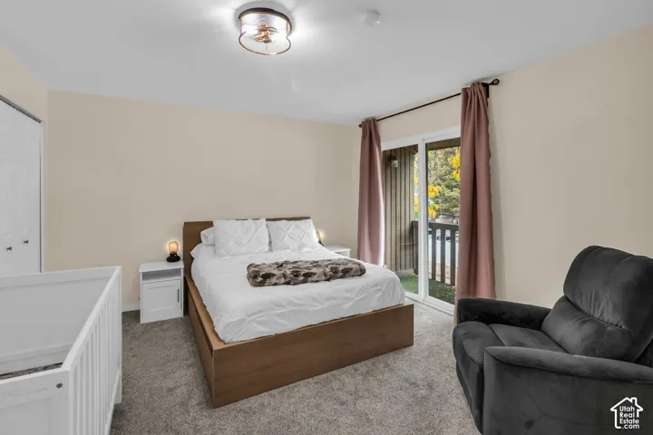 Neutral-toned interior featuring wall-to-wall carpeting, sliding glass doors providing outdoor access, and a flush-mount drum ceiling light fixture