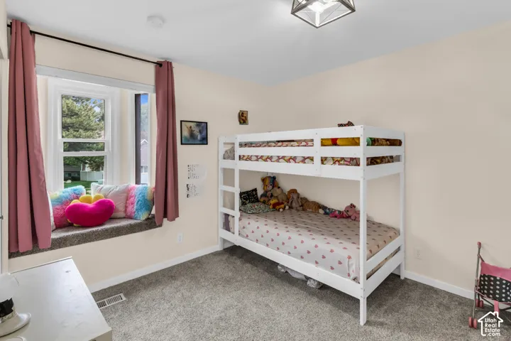 Built-in window seat, neutral wall palette, carpeting, and multi-paned window