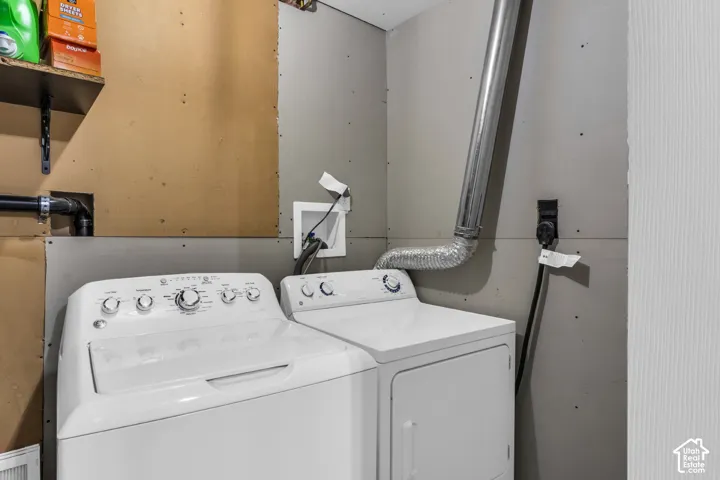 Laundry area featuring a top-load washer and dryer set, dedicated electrical outlet, and integrated dryer ventilation ducting