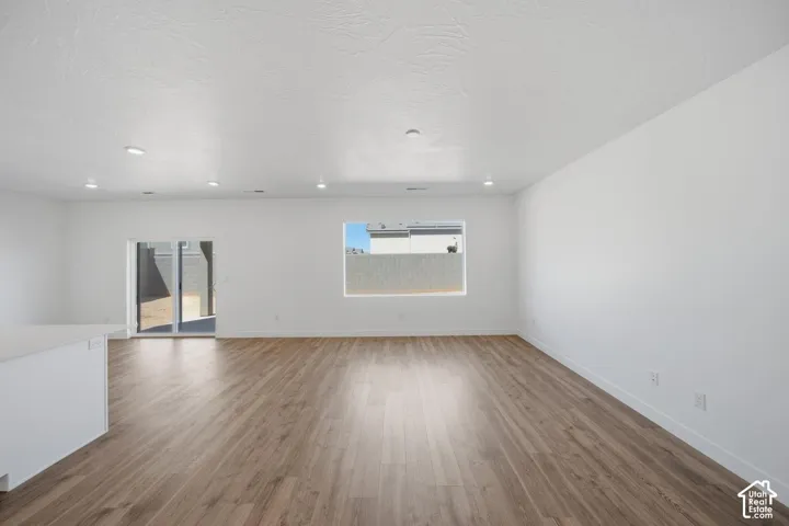 Open-concept interior featuring wood-finish flooring, recessed lighting, and a sliding glass door