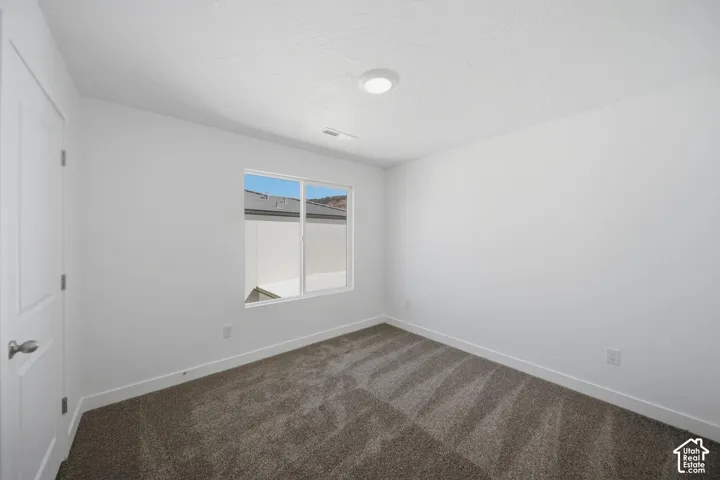 Neutral-toned carpeting, single-panel interior door with satin nickel hardware, and recessed ceiling lighting