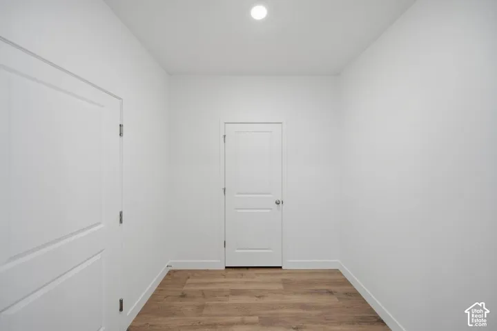 Interior space featuring wood-finish flooring, two-panel interior doors, and recessed ceiling lighting
