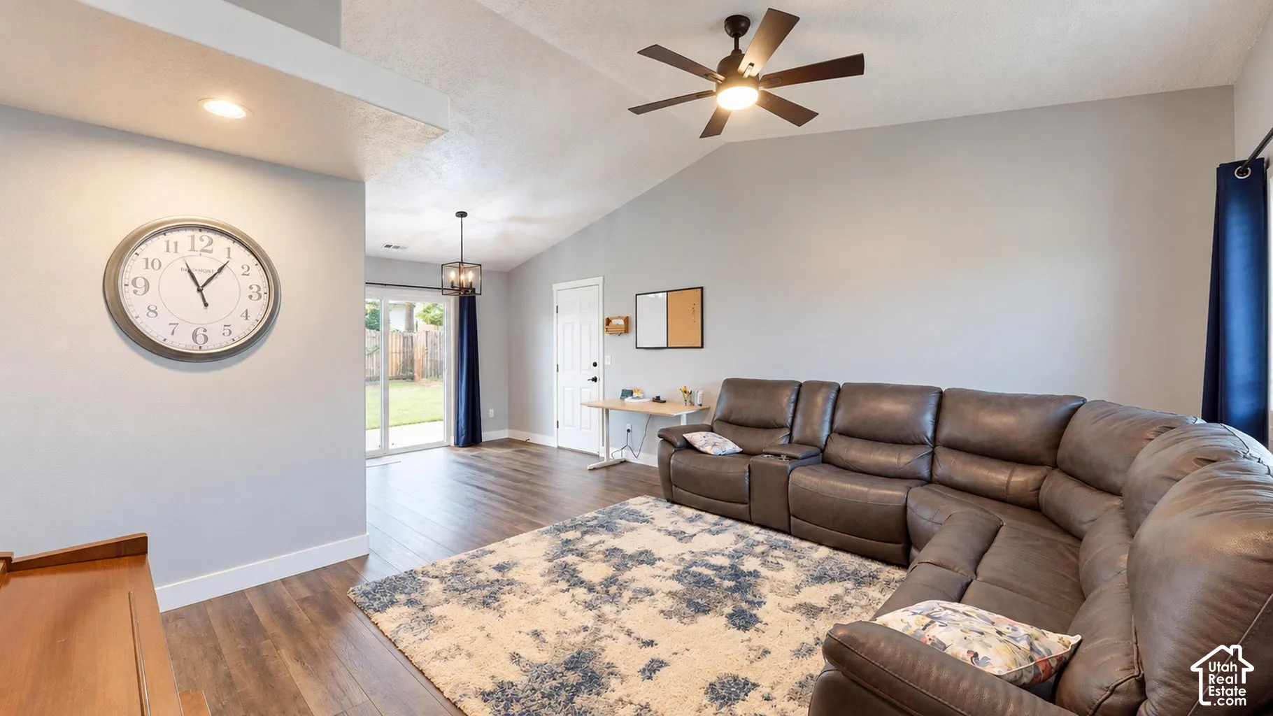Vaulted ceilings featuring a centrally mounted ceiling fan, wood-finish flooring, recessed lighting, and a sliding glass door
